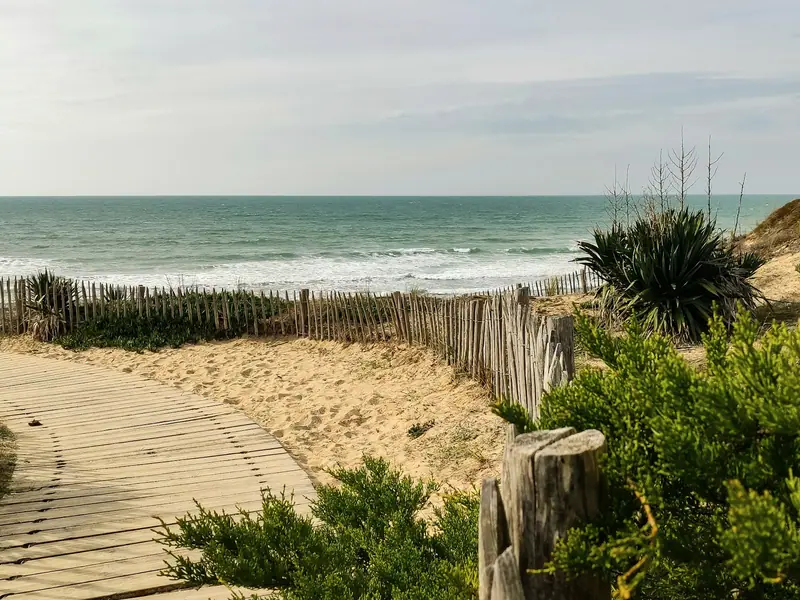Un chemin en caillebotis dans les dunes, vers l’océan