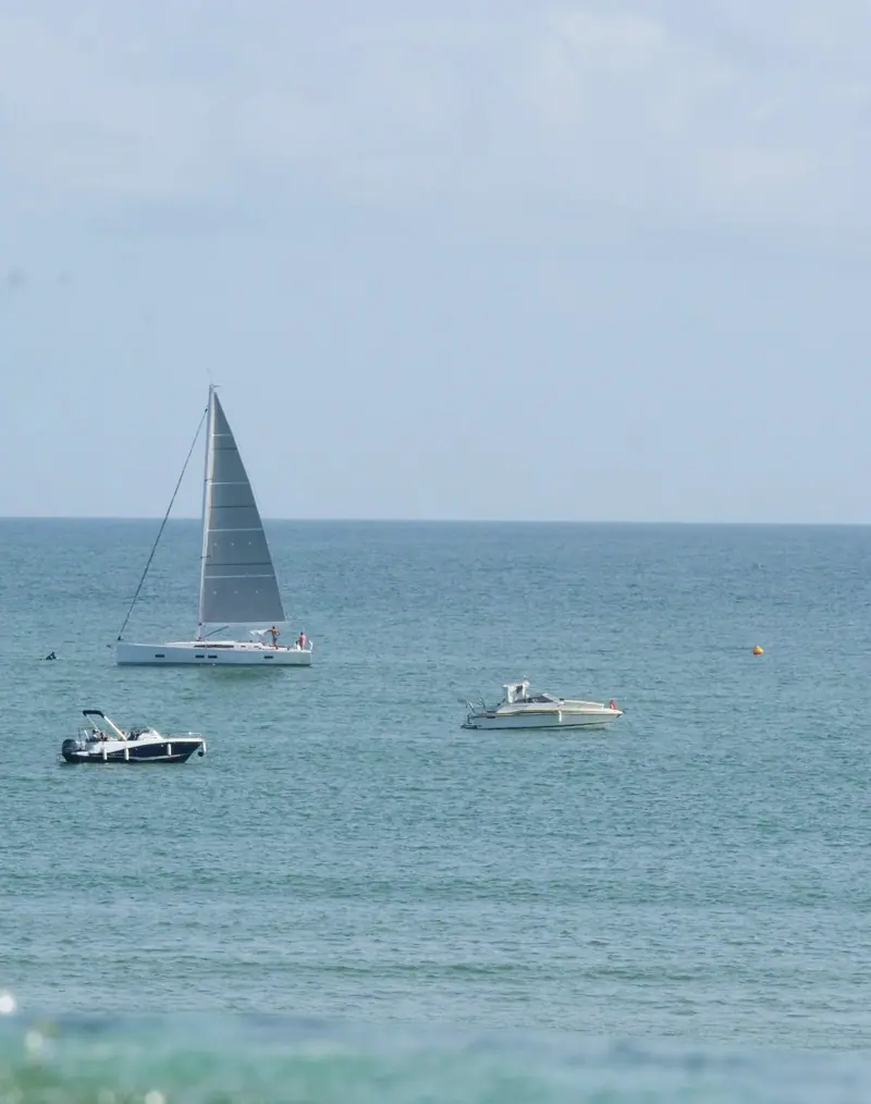 Un voilier au large, vu depuis la promenade
